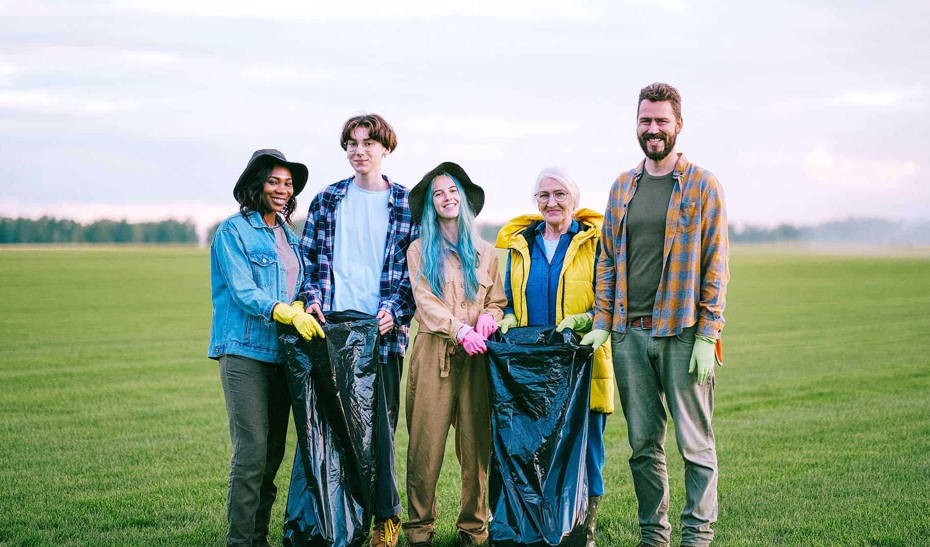 https://www.pexels.com/photo/volunteers-standing-on-green-grass-field-while-holding-black-plastic-bags-5029856/